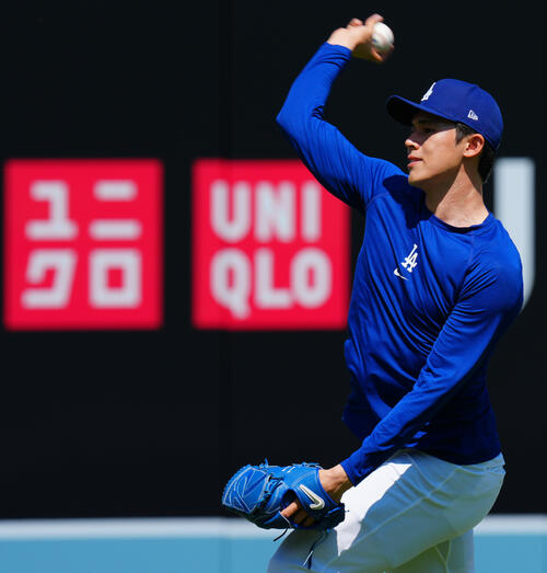 ドジャース対ダイヤモンドバックス ユニクロの広告を背に投球練習するドジャース佐々木(撮影・垰建太)