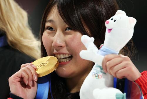 スノーボード女子ビッグエアで獲得した金メダルをかむ村瀬心椛（ロイター）