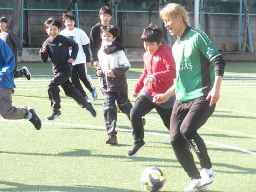 小学生とサッカーを楽しむ東京Vの稲見哲行（右）