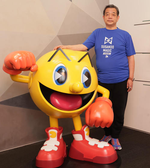 パックマンと写真に納まるバンダイナムコエンターテインメント宮河社長(22年3月)