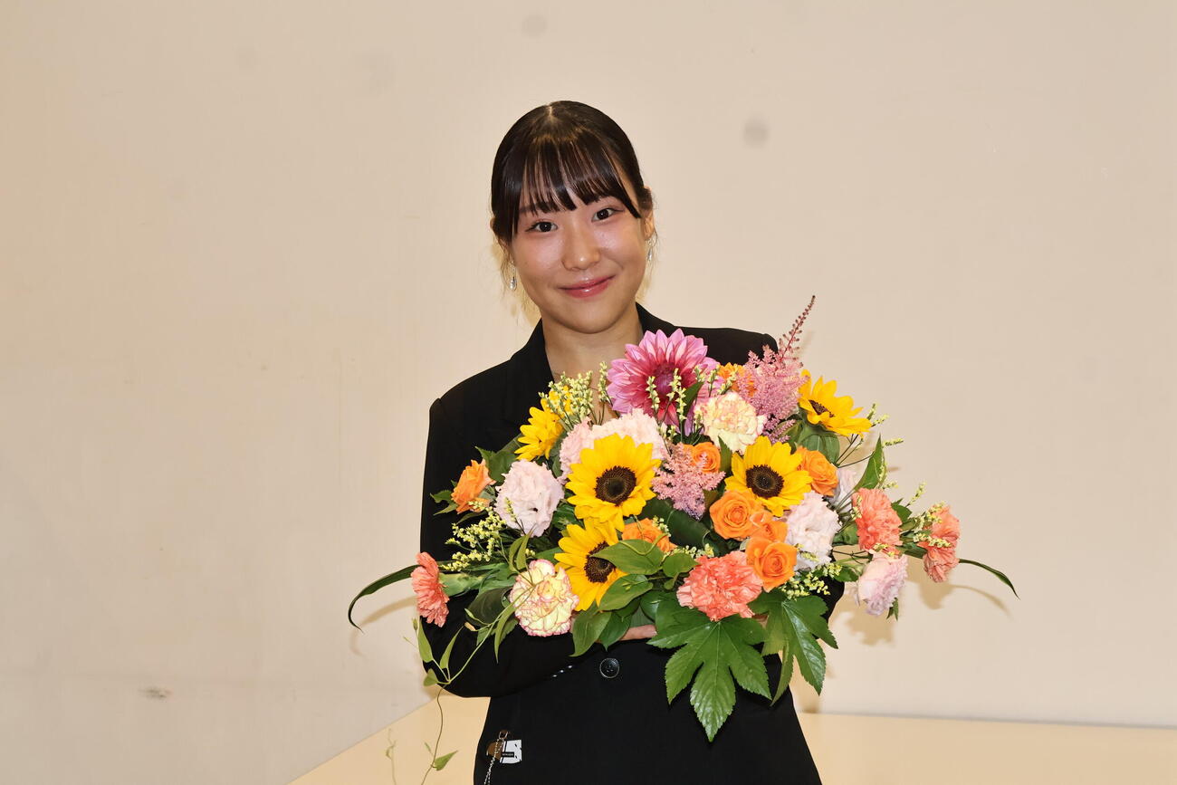 花を抱えて笑う三原舞依さん（撮影・竹本穂乃加）